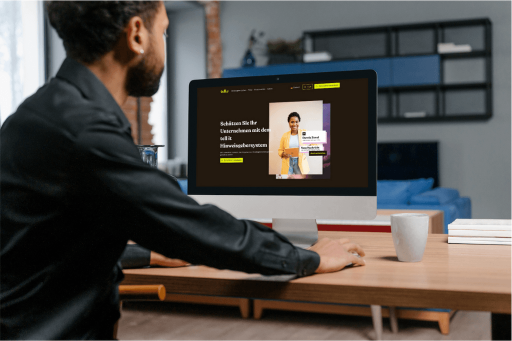 Person am Schreibtisch vor Computer mit tell it Webseite.